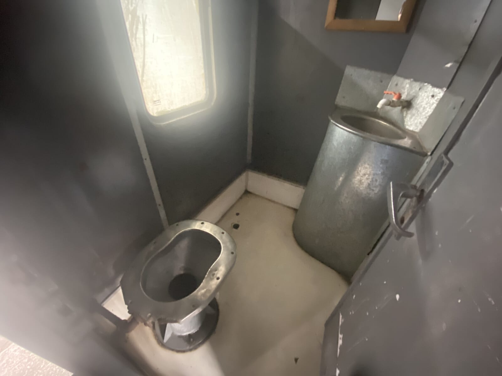 ジョージア鉄道の車内にあるステンレス製のトイレと洗面台